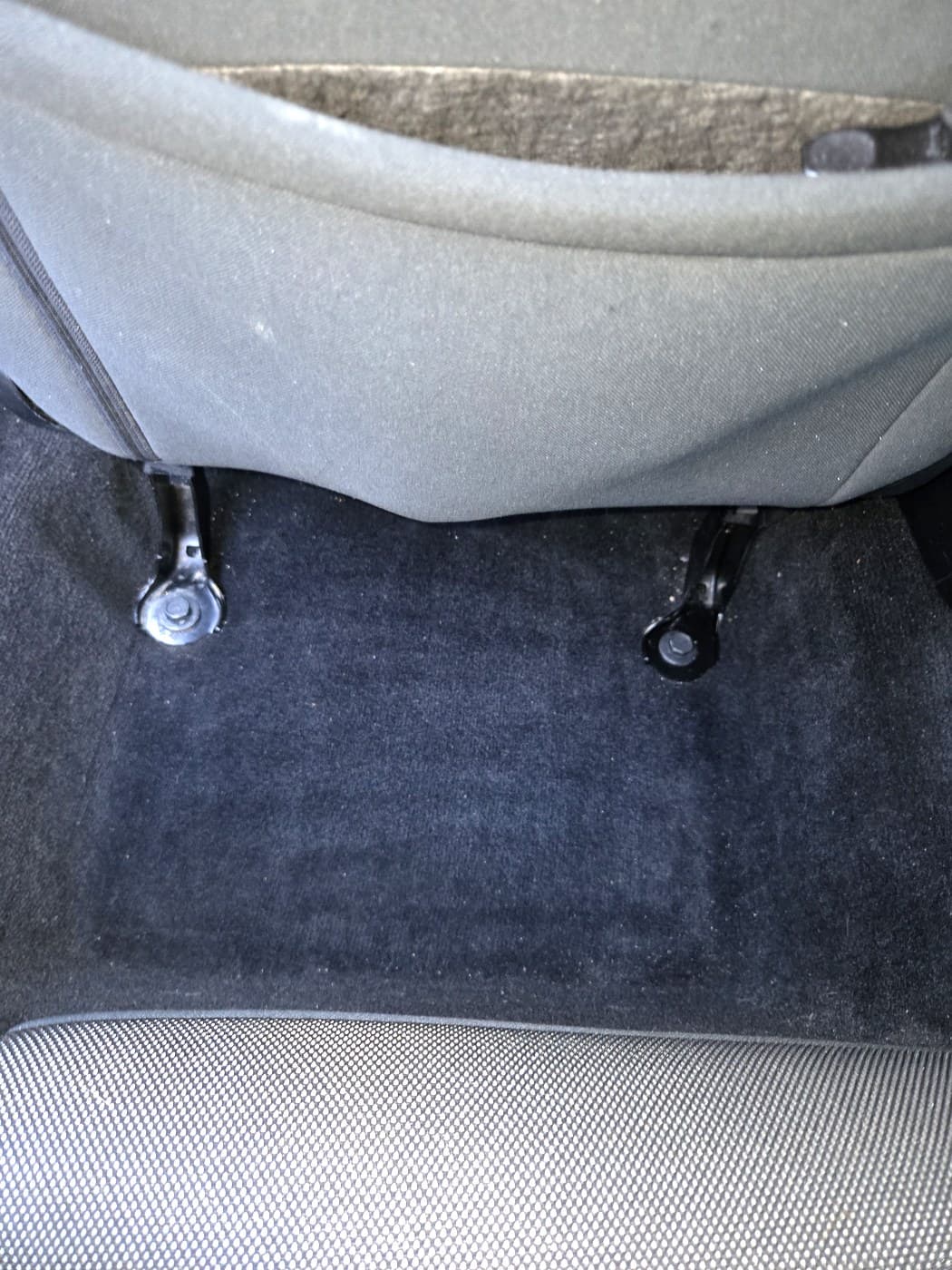 Rear passenger floor after dry cleanup with the floor mat removed.